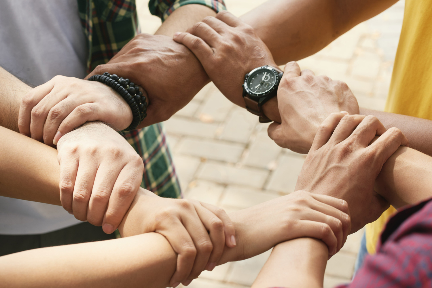 cropped-friends-holding-wrists-each-othe-chain-support-collaborate